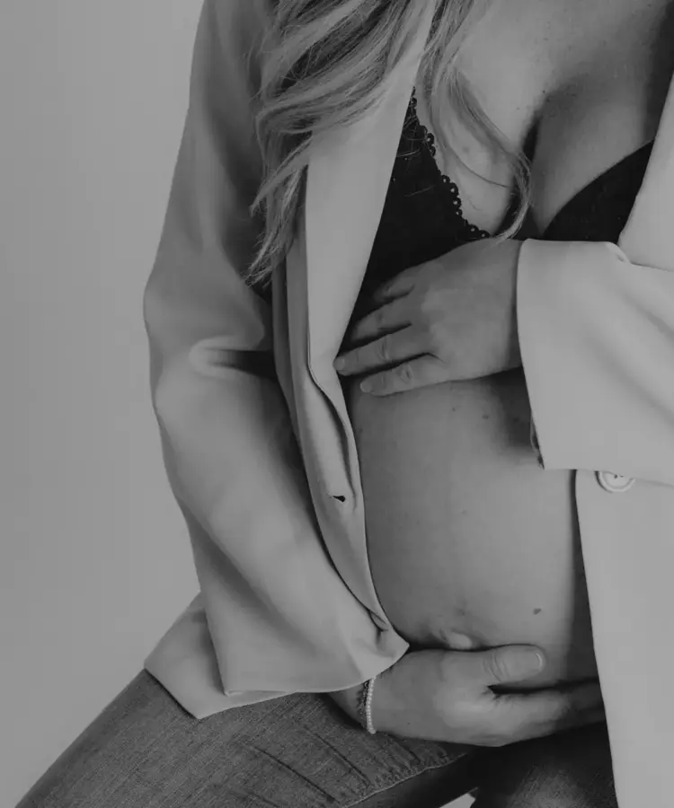 Babybauchfotografie Dortmund - Schwangere Frau mit offenem Blazer und Babybauch in Schwarz-Weiß-Studioaufnahme als Babybauchfotografie in Dortmund